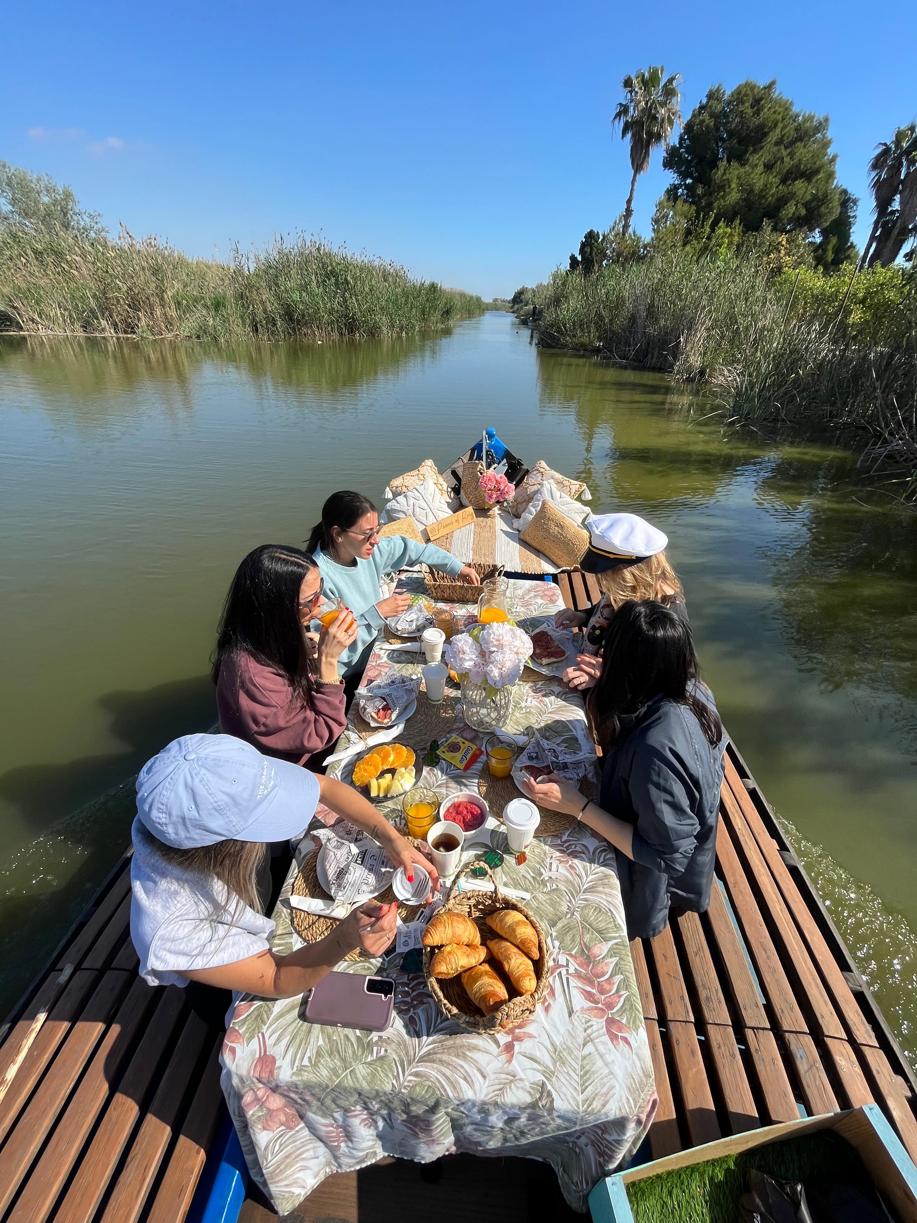 Mesa de brunch preparada a bordo de una barca en la Albufera de Valencia con vistas al lago