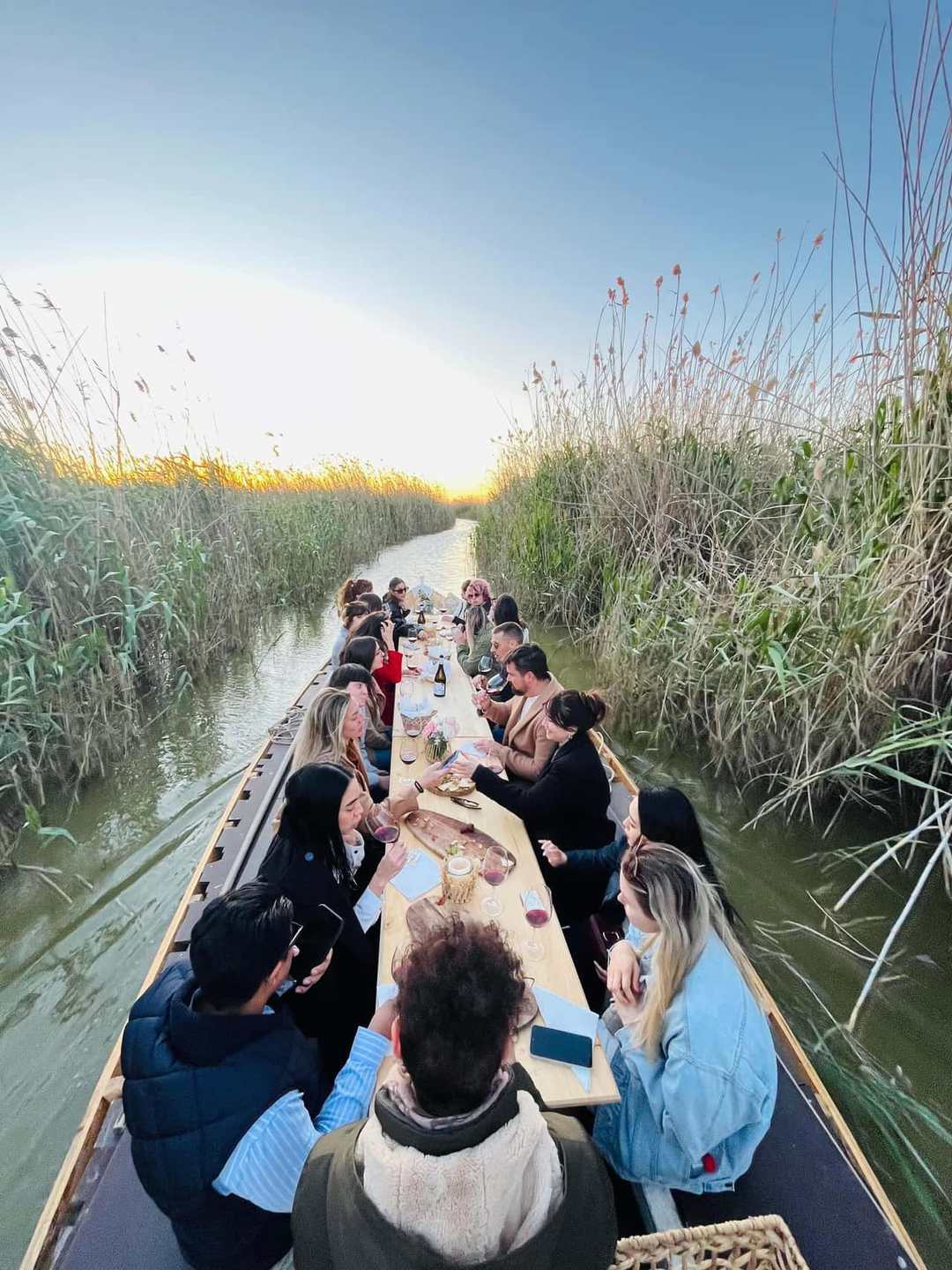 Copa de vino tinto al atardecer en una barca de la Albufera de Valencia