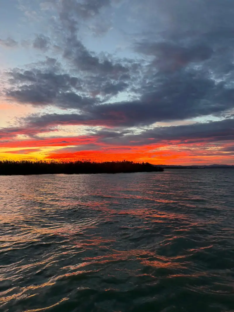 Cielo rojizo dramático durante puesta de sol sobre la Albufera de El Palmar
