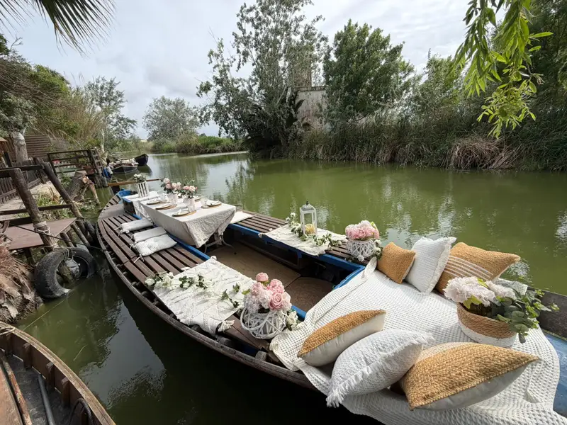 Barca tradicional decorada con rosas y mesa romántica en canal de la Albufera