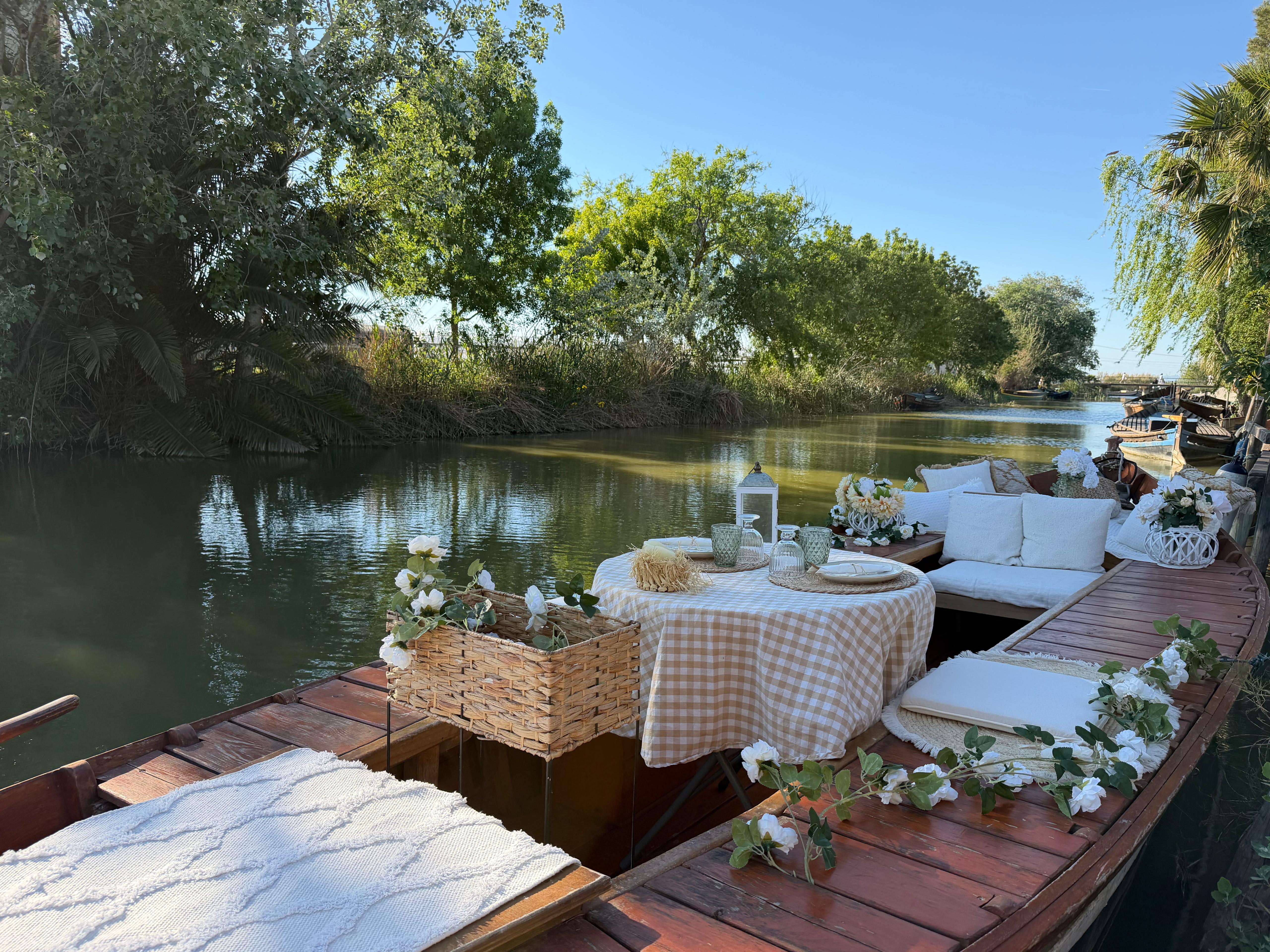 Detalle de la decoración romántica en barca: velas, flores y cava para dos en la Albufera