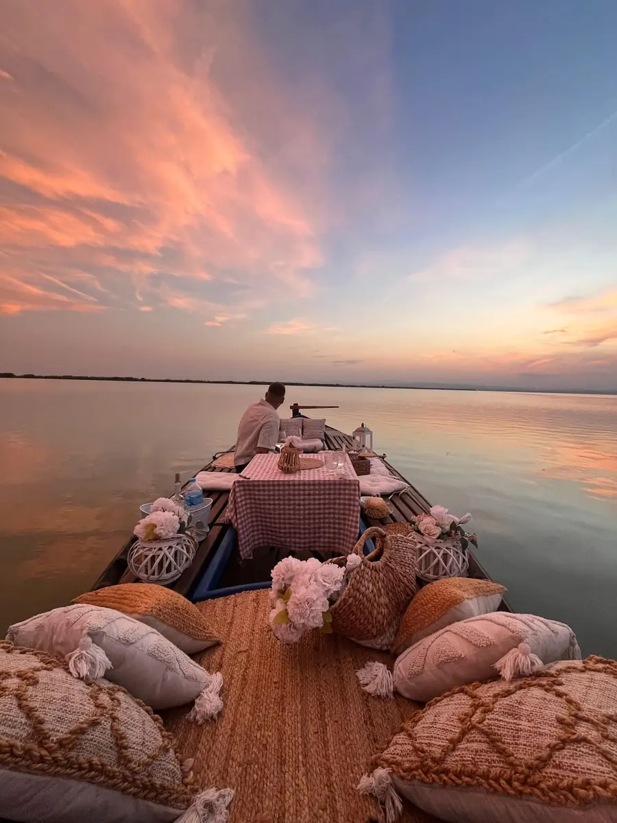 Mesa romántica decorada en barca al atardecer sobre el lago de la Albufera