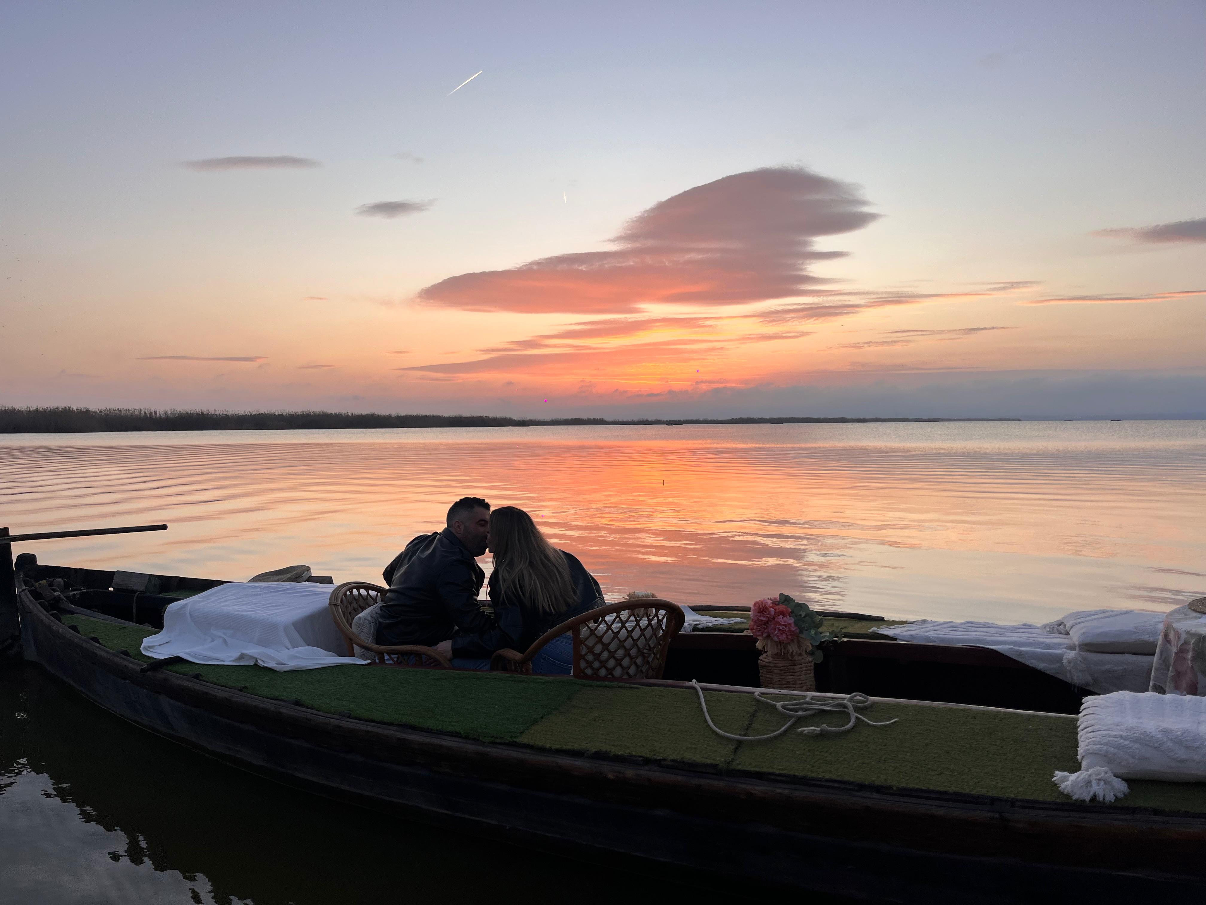 Pareja en barca privada viendo la puesta de sol sobre el lago de la Albufera de Valencia