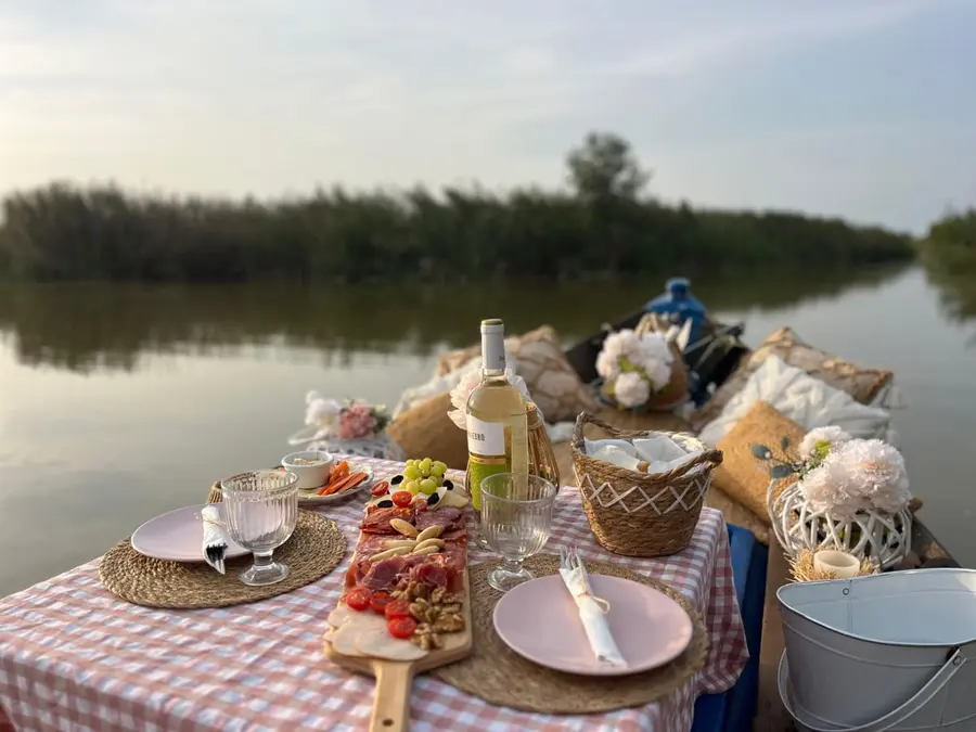 Tabla de ibéricos y embutidos con vino en barca romántica en la Albufera de Valencia