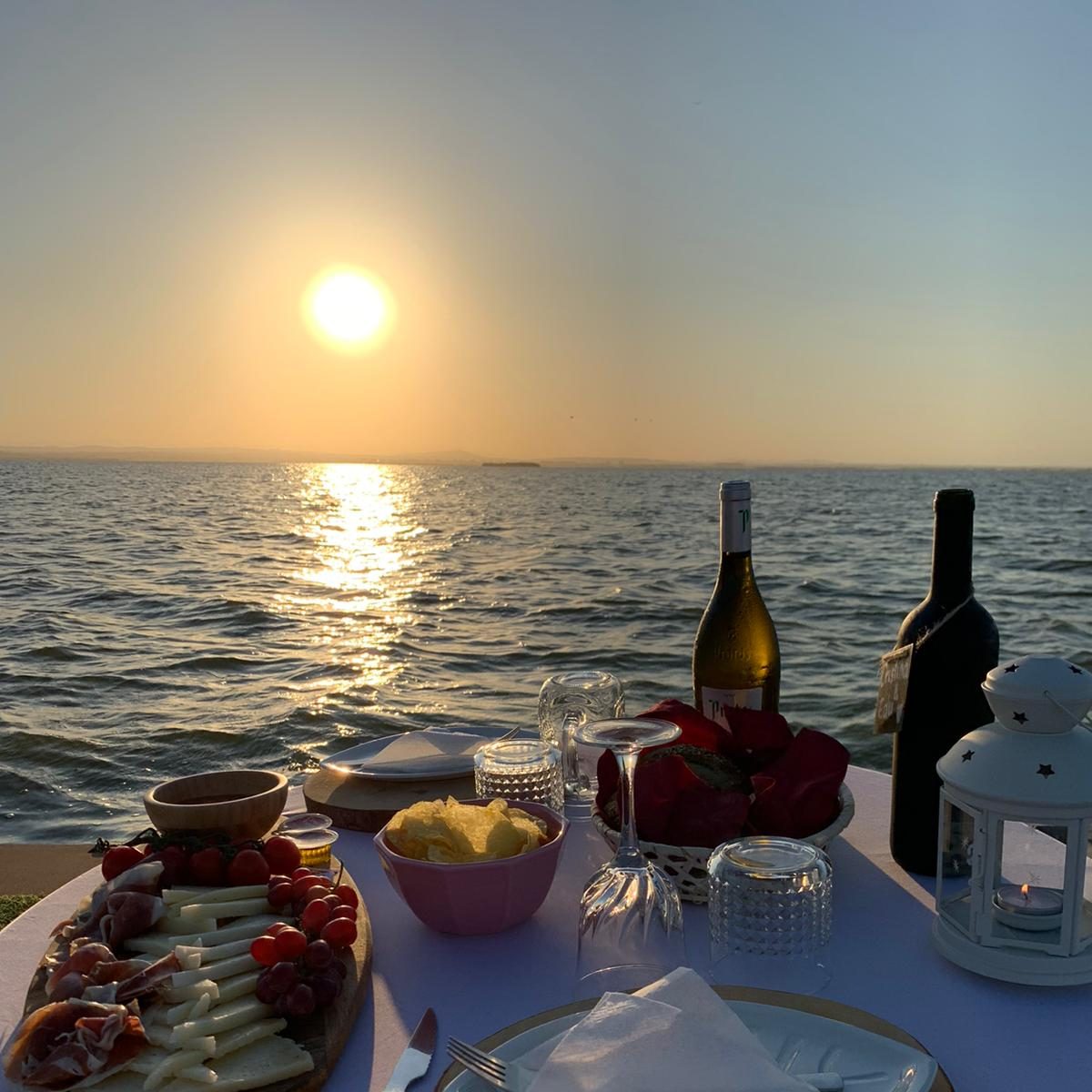 Puesta de sol con copa de vino en barca sobre la Albufera de Valencia